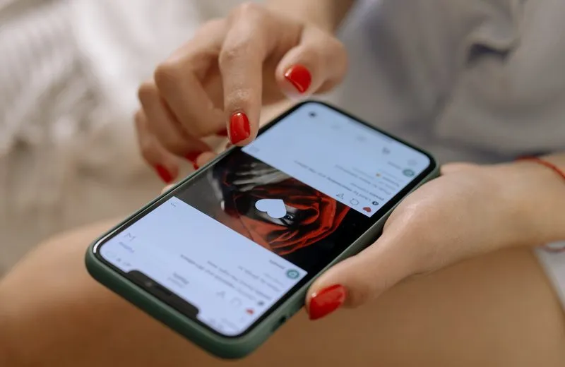 Hand scrolling through a social media feed on a smartphone
